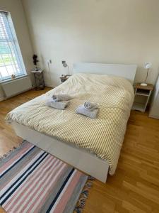 a bed with two towels on it in a room at Whole Flat Close To Wembley in Wealdstone