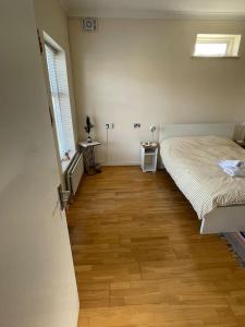 a bedroom with a bed and a wooden floor at Whole Flat Close To Wembley in Wealdstone
