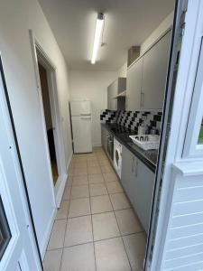 a kitchen with a sink and a refrigerator at Whole Flat Close To Wembley in Wealdstone