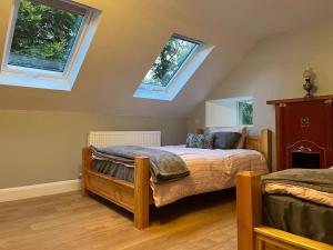 1 Schlafzimmer mit 2 Betten und 2 Fenstern in der Unterkunft Wood House Lodge in Tipperary