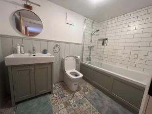 y baño con lavabo, aseo y espejo. en Wood House Lodge, en Tipperary