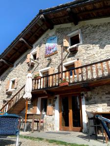 an old stone building with a wooden balcony at Chalet del Lago in Ceresole Reale