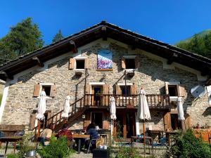 a stone building with umbrellas in front of it at Chalet del Lago in Ceresole Reale