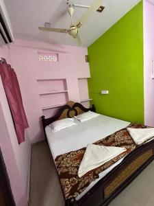 a small room with a bed with a green wall at Hotel R residence in Srīsailam