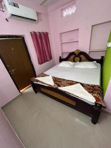 een slaapkamer met een bed in een kamer met roze muren bij Hotel R residence in Srīsailam