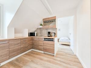 een keuken met houten kasten en een wastafel bij RAJ Living - 3 Zimmer Wohnung mit Balkon - 25 Min zur Messe DUS in Heiligenhaus