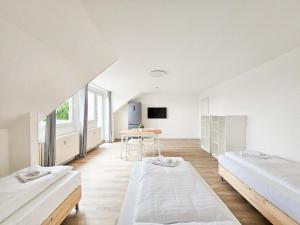 een grote witte kamer met 2 bedden en een tafel bij RAJ Living - 3 Zimmer Wohnung mit Balkon - 25 Min zur Messe DUS in Heiligenhaus