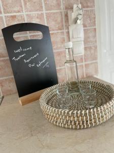a bottle of wine in a basket with glasses at Tsachaki Apartment Pigi Rethymno in Pigi