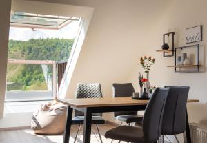 a dining room with a table and chairs and a window at Die Nummer eins - Ferienwohnungen Hufnagel in Bodenwerder