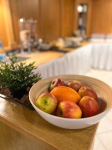 a bowl of apples and oranges on a counter at Hotel Fränkischer Hof in Kitzingen