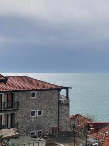 a large brick building with the ocean in the background at Apartments Gusar in Ulcinj