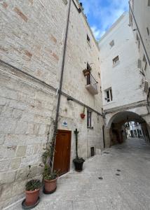a large stone building with a door in a courtyard at Arco Sallustio 2.0 in Monopoli