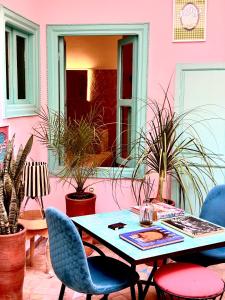 einen Tisch und Stühle vor einem rosa Gebäude in der Unterkunft Riad Lauriers Blancs in Marrakesch