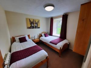 a bedroom with two beds and a window at Holiday Cottage 6 in Watermillock
