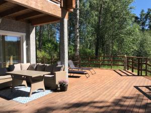 un patio con mesa y sillas en una terraza de madera en Villa Kägöne, en Parikkala