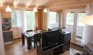 Una sala de estar con televisión y un comedor. en Villa Kägöne, en Parikkala