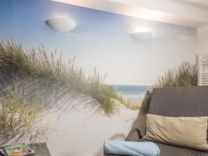 a room with a chair and the beach at Appartementresidenz 4 Seasons in Timmendorfer Strand