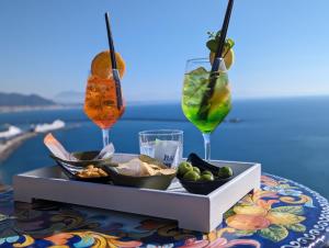 a tray of food on a table with two drinks at Villa Carosino in Vietri sul Mare