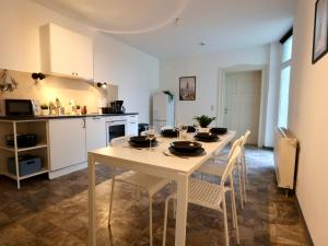 uma cozinha com uma mesa branca e cadeiras num quarto em Apartment mit Wasserblick em Bernburg