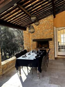 a dining table in a patio with a brick wall at Domaine des Figons in Éguilles