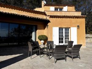 a patio with chairs and a table in front of a building at Domaine des Figons in Éguilles