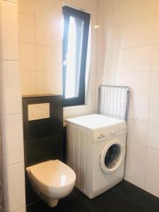 a bathroom with a washing machine and a toilet at City Zen Apartment Enschede !Free Private Parking in Enschede