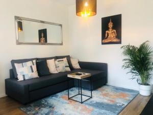 sala de estar con sofá negro y mesa en City Zen Apartment Enschede !Free Private Parking, en Enschede