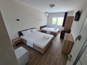 ein kleines Zimmer mit 2 Betten und einem Fenster in der Unterkunft Pensiunea Casa Albă in Tuzla