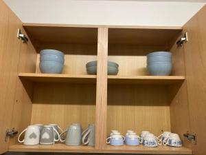a cupboard with blue bowls and dishes on it at Central Doncaster 5BED 3BATH ParkView Mansion in Doncaster