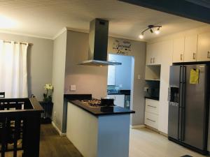 a kitchen with a black counter top and a refrigerator at Bella Hideaway in East London