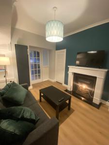 sala de estar con sofá y chimenea en Newly Furnished 5 Bedroom Gem in Sligo, en Sligo