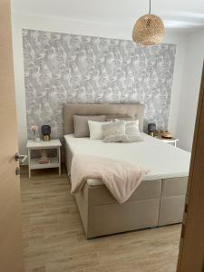 a bedroom with a large bed with a wall at M RESIDENCE in Petrcane +6 photos