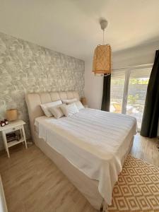 a bedroom with a large white bed and a window at M RESIDENCE in Petrcane