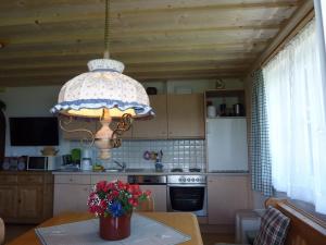 eine Küche mit einem Kronleuchter über einem Tisch in der Unterkunft Haus Rigl in Vorberg