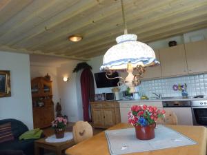 eine Küche mit einem Tisch und einer Blumenvase darauf in der Unterkunft Haus Rigl in Vorberg