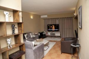 a living room with a couch and a tv at AJ HOMES in Benin City