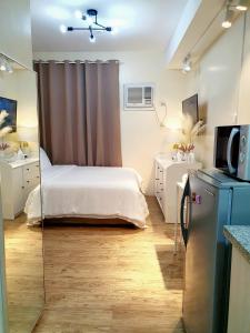 um pequeno quarto com uma cama e um espelho em Serenity Condo: Your Cozy Place At Stanford Suites 2 w/ Private Parking em Silang