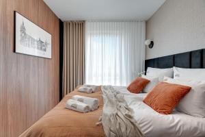 a bedroom with a large bed with towels on it at Nadmotławie Riverside - Gym & Free Parking by Downtown Apartments in Gdańsk +37 photos