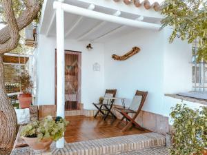 un porche de una casa con mesa y sillas en La Luciérnaga, en Chiclana de la Frontera