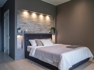 a bedroom with a large bed with a brick wall at SkyGarden Studio in Jūrmala