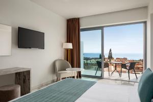 een hotelkamer met een bed en een groot raam bij Ramada Hotel & Suites by Wyndham Ayia Napa in Ayia Napa