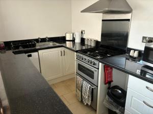 a kitchen with a stove and a sink at Nanny and Chips House in Whitby