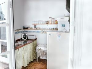 a small kitchen with a refrigerator and a sink at La Luciérnaga in Chiclana de la Frontera