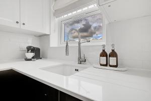 two bottles of wine sitting on a kitchen sink at Quality Apartments Close to Tube in Hendon