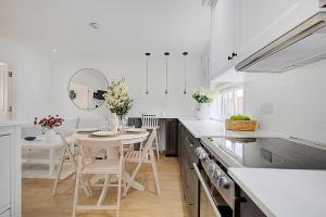 eine Küche mit einem Tisch, Stühlen und einem Spiegel in der Unterkunft Quality Apartments Close to Tube in Hendon