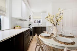 ヘンドンにあるQuality Apartments Close to Tubeの白いキッチン(テーブル、椅子付) +49枚の写真