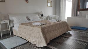 ein weißes Schlafzimmer mit einem großen Bett und einem Fenster in der Unterkunft Tenuta il Bosco in Bitonto
