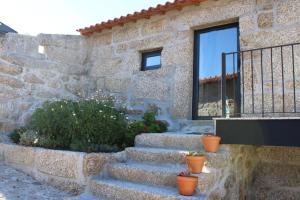 uma casa de pedra com escadas e uma janela em Villa Seara - Casas da Vinha em Celorico de Basto