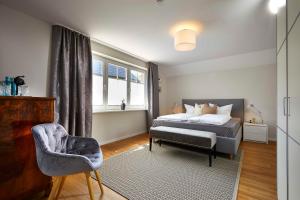 ein Schlafzimmer mit einem Bett, einem Stuhl und einem Fenster in der Unterkunft edo Ferienzimmer in Dangast