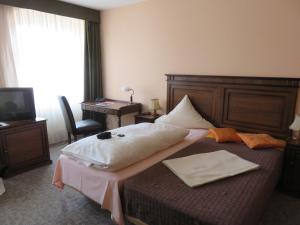 a hotel room with a large bed and a desk at AM RATSHOF in Halle an der Saale